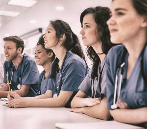 Medical students listening sitting at desk