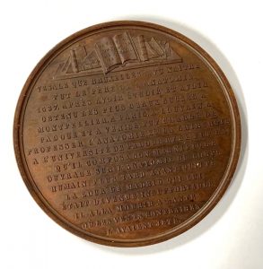 Books and French transcription on a medal