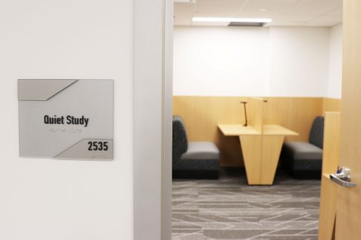 A sign reading "Quiet Study" outside of a room where study carrels are visible