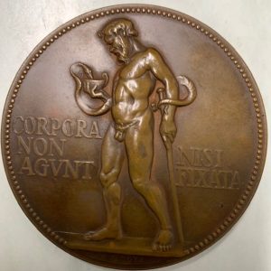 A bronze medallion with the figure of a man and a Latin phrase